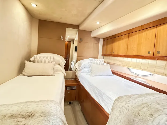Lai Lani Yacht Photos Pics Twin cabin interior of 2005 Sunseeker Manhattan 66 yacht, featuring cozy beds and wooden accents.