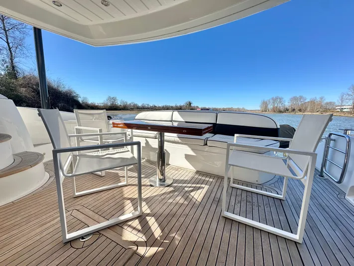 Lai Lani Yacht Photos Pics Sunseeker Manhattan 66 yacht deck with modern seating, wooden flooring, and scenic river view.