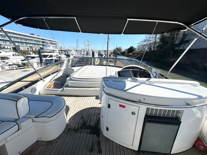 Lai Lani Yacht Photos Pics 2005 Sunseeker Manhattan 66 yacht deck with seating and helm, docked at marina.