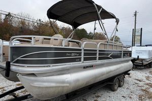 2019 Sun Tracker Fishin' Barge 22 XP3 pontoon boat on a trailer, parked outdoors.