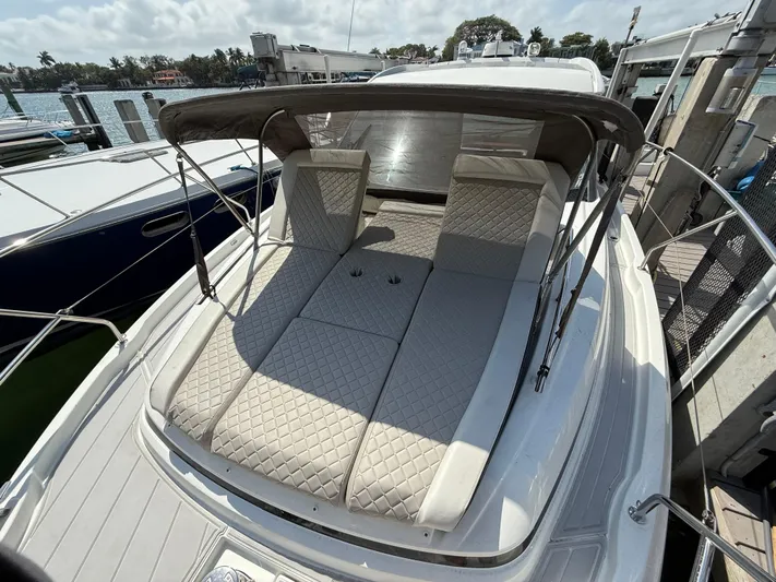  Yacht Photos Pics 2020 Jeanneau NC 37 boat with cushioned sunbathing area and canopy, docked at marina.