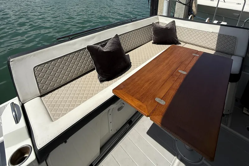  Yacht Photos Pics Luxurious seating area on 2020 Jeanneau NC 37 yacht with wooden table and cushions.