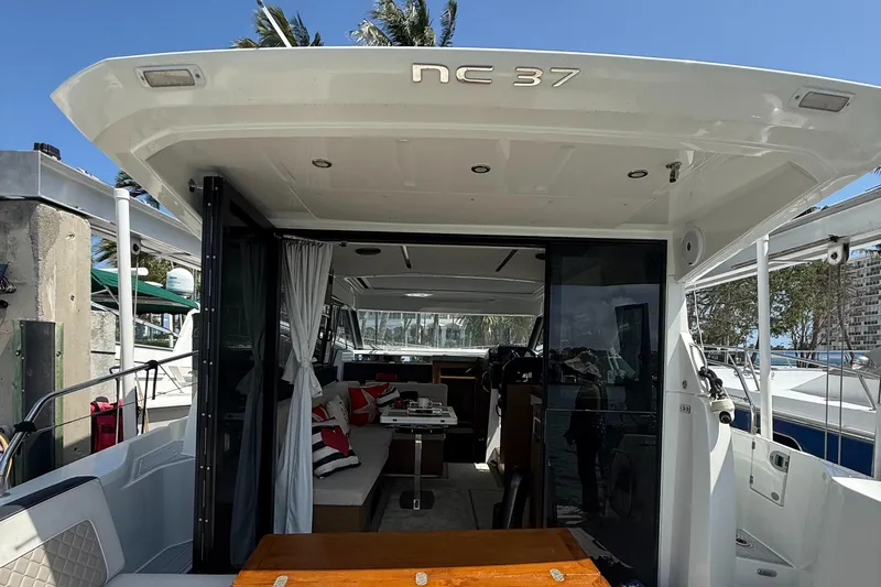 Yacht Photos Pics 2020 Jeanneau NC 37 yacht interior with seating and table, docked at marina.