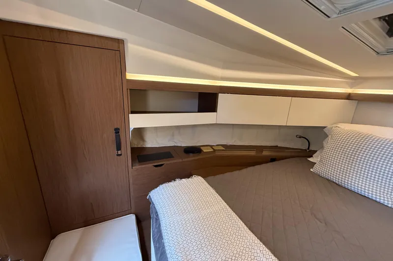  Yacht Photos Pics 2020 Jeanneau NC 37 cabin interior with modern wood finish and cozy bedding.