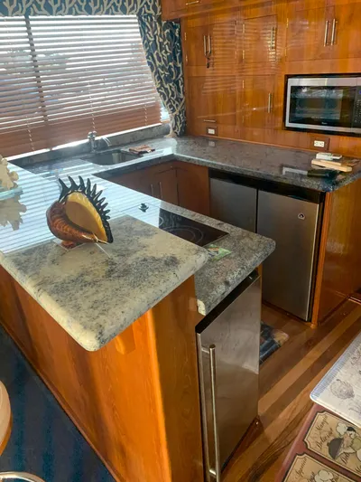 Lolly Yacht Photos Pics 1985 Ocean Yachts 55 Super Sport kitchen with granite countertops and wooden cabinetry.