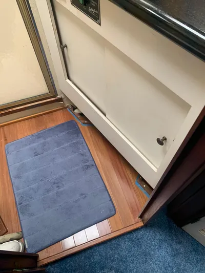 Lolly Yacht Photos Pics 1985 Ocean Yachts 55 Super Sport interior with wooden flooring and blue rug.