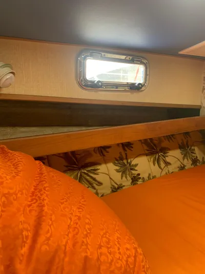 Lolly Yacht Photos Pics Interior cabin of 1985 Ocean Yachts 55 Super Sport with orange bedding and porthole.