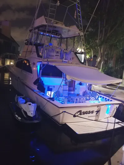 Lolly Yacht Photos Pics 1985 Ocean Yachts 55 Super Sport docked at night with blue lights.