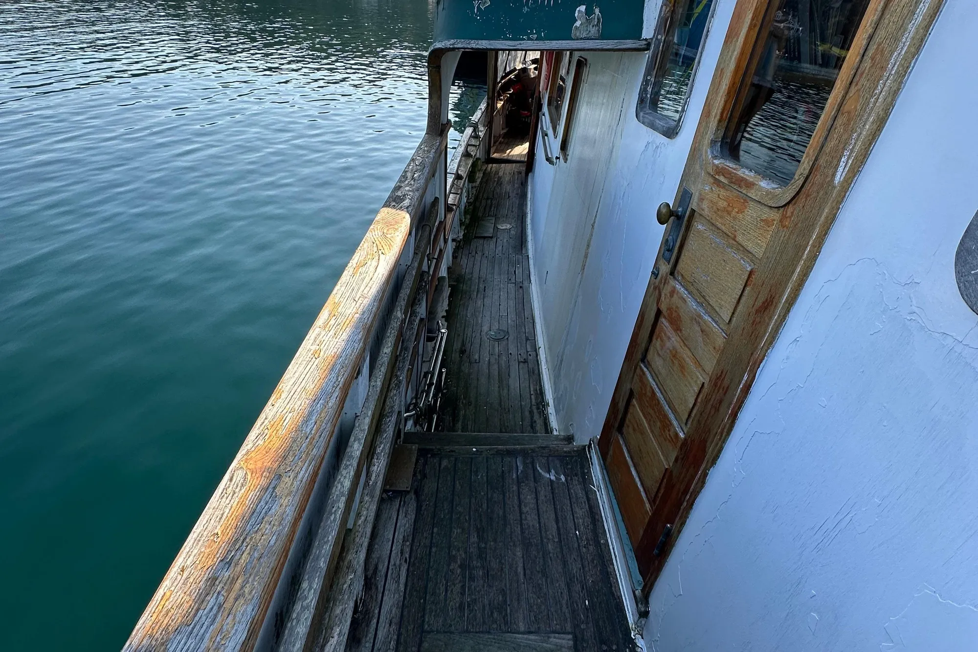 Wooden deck and door of 1971 Southern Marine MALAHIDE Pilothouse LRC by the water.