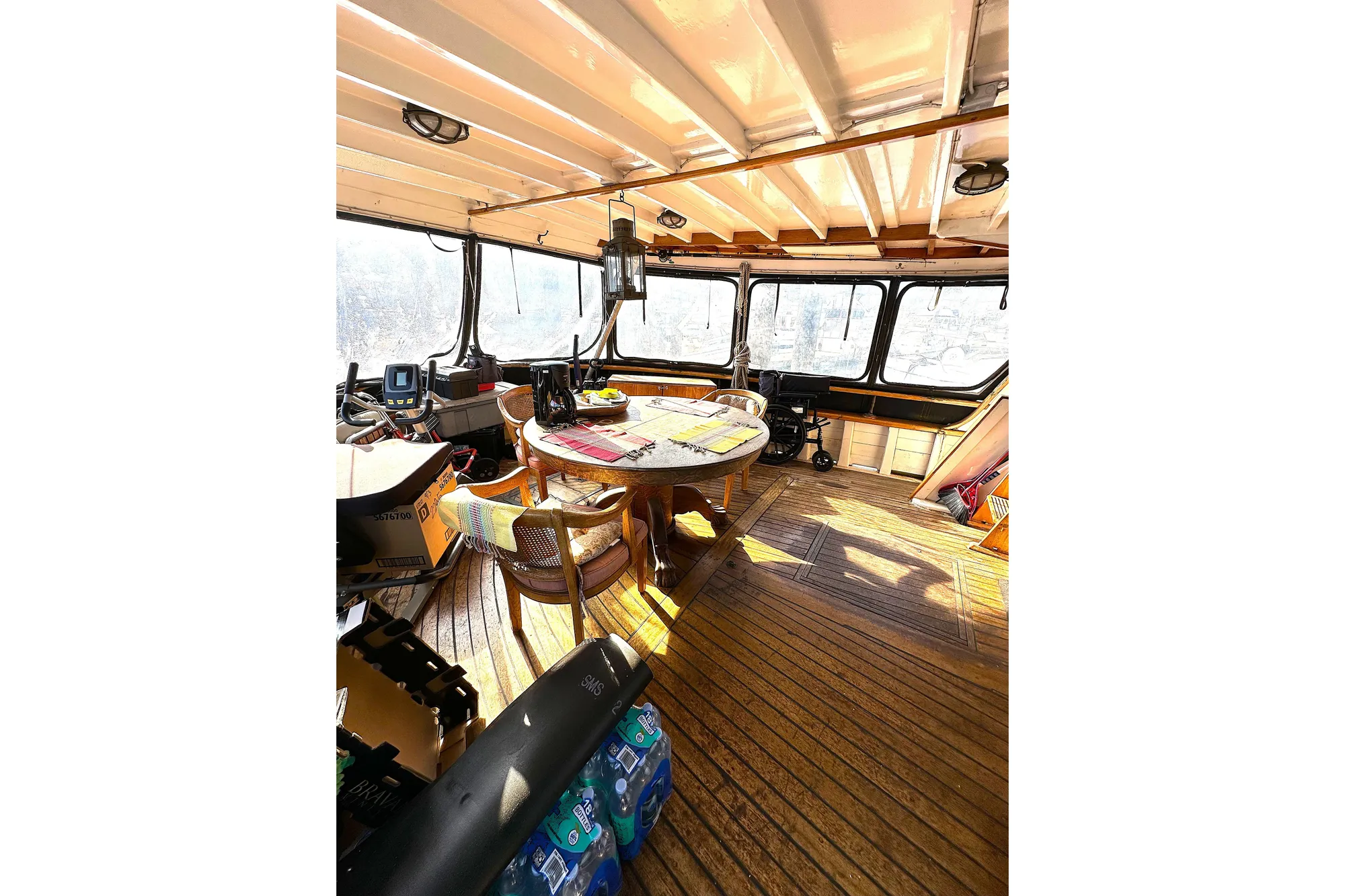 Pilothouse interior of 1971 Southern Marine MALAHIDE, featuring wooden flooring and panoramic windows.
