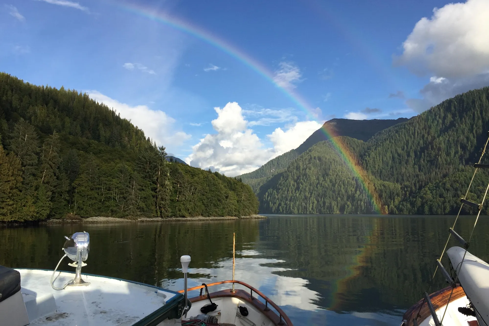 Southern Marine MALAHIDE Pilothouse LRC (1971) cruising under a vibrant rainbow in a serene lake.