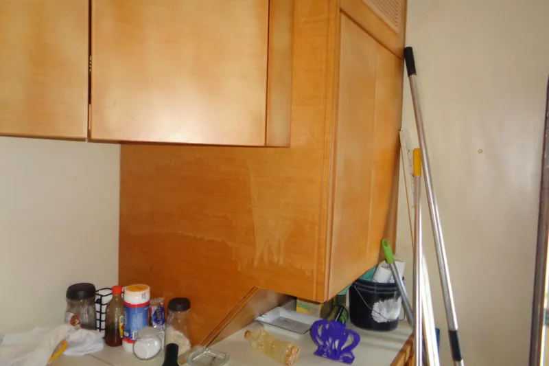 (project Boat) 1995 Azimut 78ultra @ixtapa-mexico Yacht Photos Pics Interior of 1995 Azimut 78 Ultra Motoryacht with wooden cabinets and cleaning supplies.