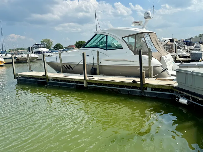  Yacht Photos Pics 2009 Cruisers Yachts 420 Coupe docked at marina under cloudy sky.