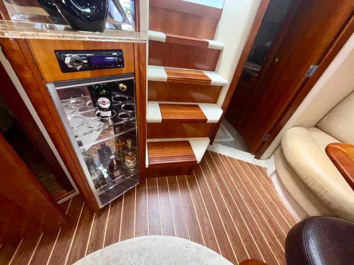 Yacht Photos Pics Luxurious interior of 2009 Cruisers Yachts 420 Coupe with wooden stairs and bar cabinet.