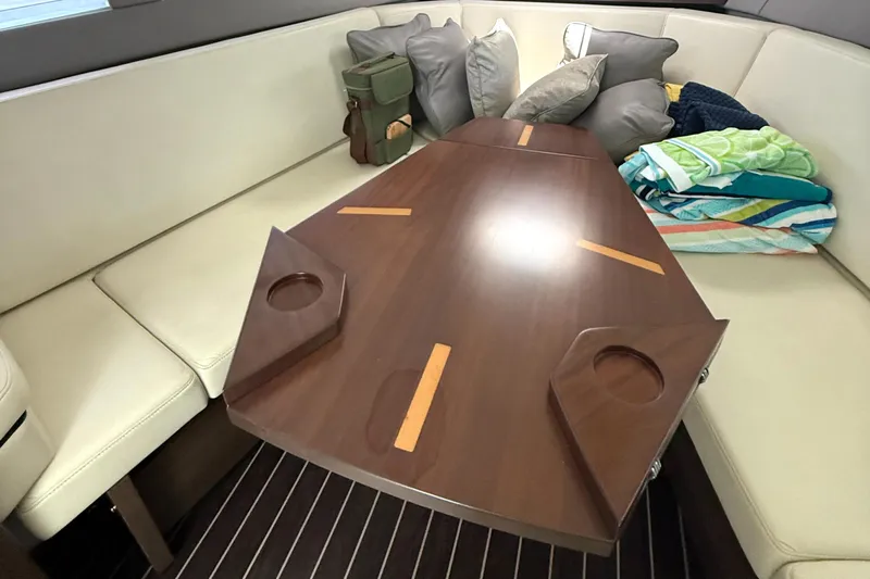  Yacht Photos Pics Interior of 2016 Monterey 360 Sport Coupe with wooden table and cushioned seating.