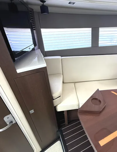  Yacht Photos Pics Interior of 2016 Monterey 360 Sport Coupe with beige seating and wooden table.