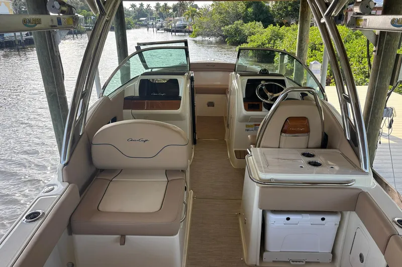  Yacht Photos Pics 2023 Chris-Craft Calypso 24 boat interior with seating and steering wheel, docked by water.