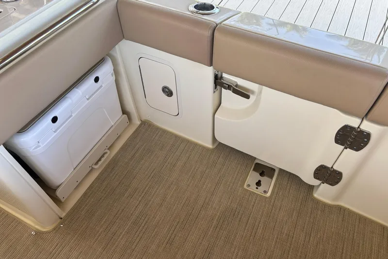  Yacht Photos Pics 2023 Chris-Craft Calypso 24 interior with storage compartment and cushioned seating.