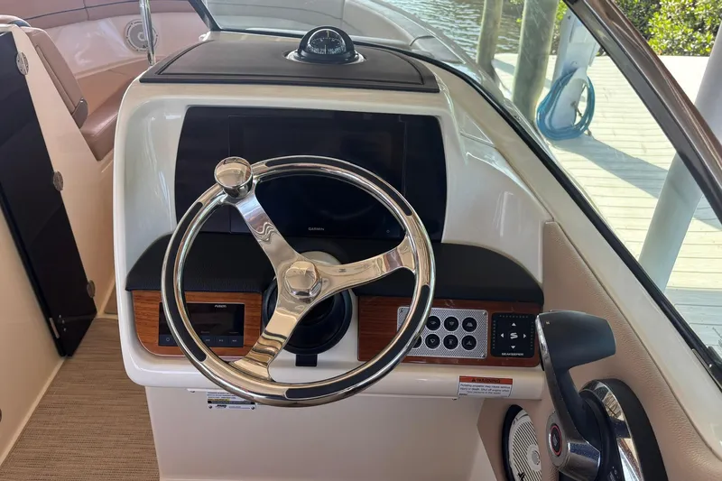  Yacht Photos Pics 2023 Chris-Craft Calypso 24 helm with steering wheel and control panel.