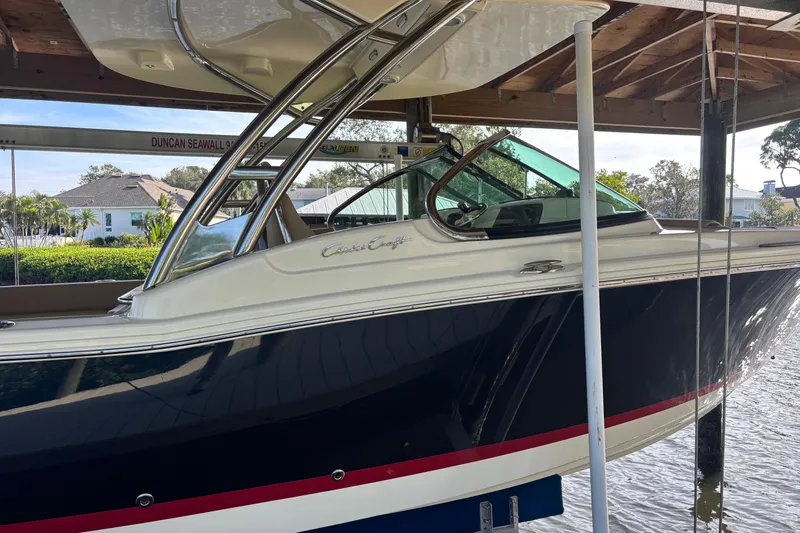  Yacht Photos Pics 2023 Chris-Craft Calypso 24 boat docked under a wooden shelter.