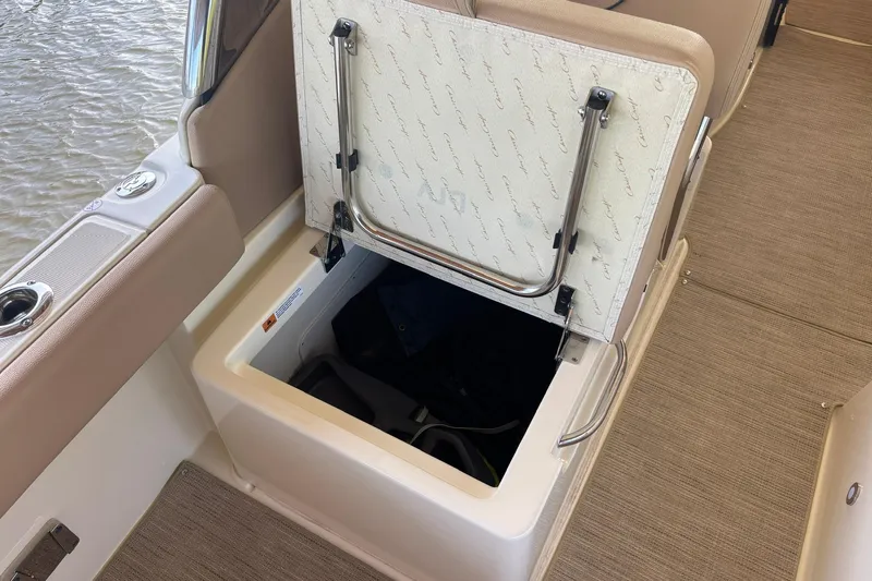  Yacht Photos Pics 2023 Chris-Craft Calypso 24 boat storage compartment with open hatch, beige interior.