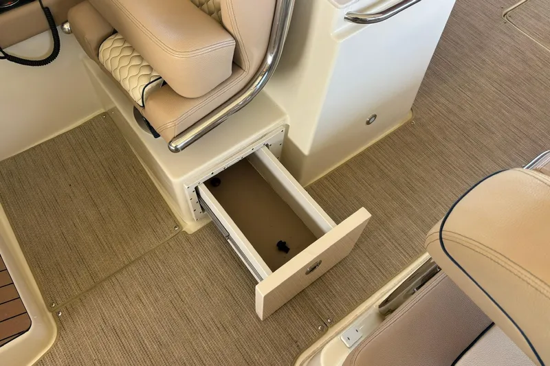  Yacht Photos Pics 2023 Chris-Craft Calypso 24 interior with open storage drawer and beige seating.