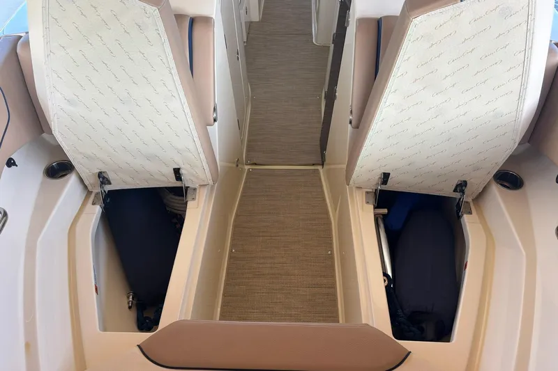  Yacht Photos Pics 2023 Chris-Craft Calypso 24 boat interior with open storage compartments and beige seating.