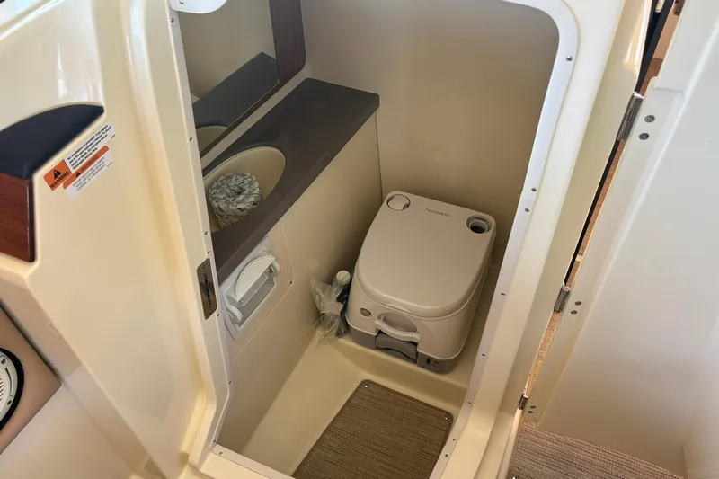  Yacht Photos Pics 2023 Chris-Craft Calypso 24 boat interior with compact marine toilet and sink.