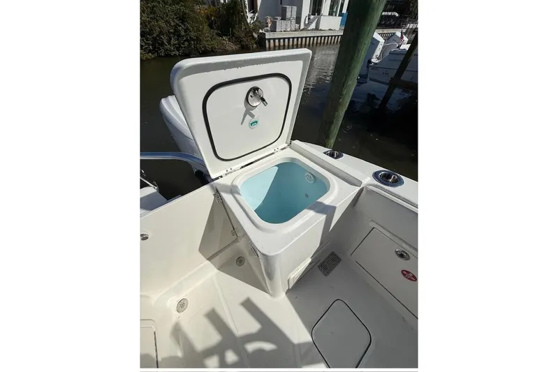 57694 325dc Yacht Photos Pics Open storage compartment on 2026 World Cat 325 DC boat, docked near water.
