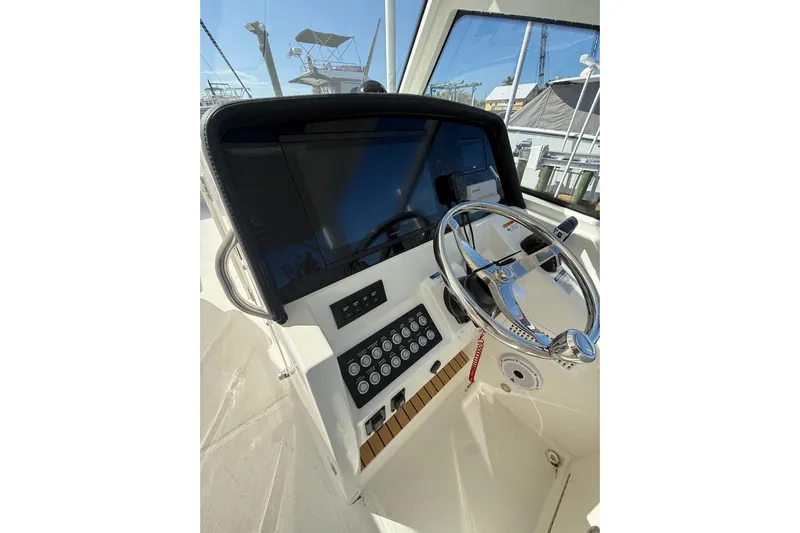 57694 325dc Yacht Photos Pics Helm of 2026 World Cat 325 DC boat with steering wheel and control panel.