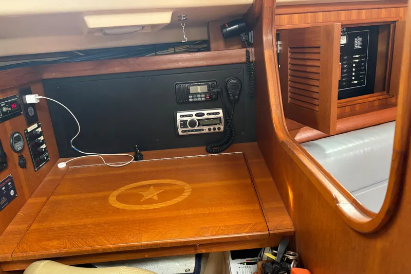 Moondance Yacht Photos Pics Interior of 2007 Island Packet 370 sailboat with navigation equipment and wooden cabinetry.