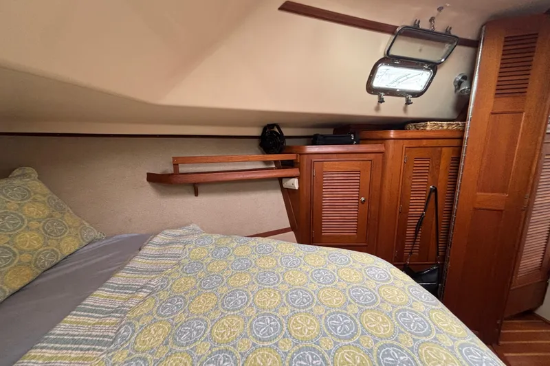 Moondance Yacht Photos Pics Cozy cabin interior of 2007 Island Packet 370 sailboat with wooden cabinetry and patterned bedding.