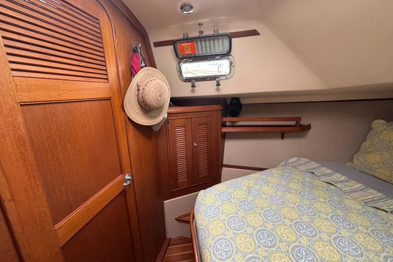 Moondance Yacht Photos Pics Cozy cabin interior of 2007 Island Packet 370 sailboat with wooden accents and bedding.
