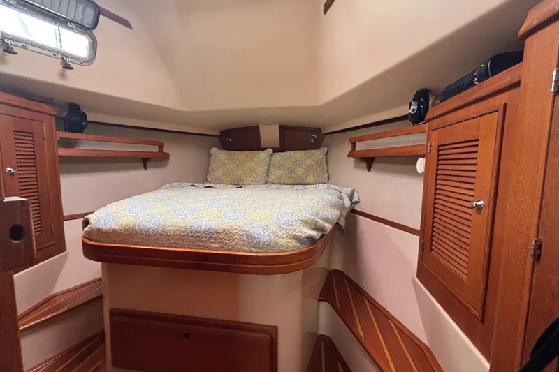 Moondance Yacht Photos Pics Cozy cabin interior of 2007 Island Packet 370 sailboat with wooden cabinetry and bed.