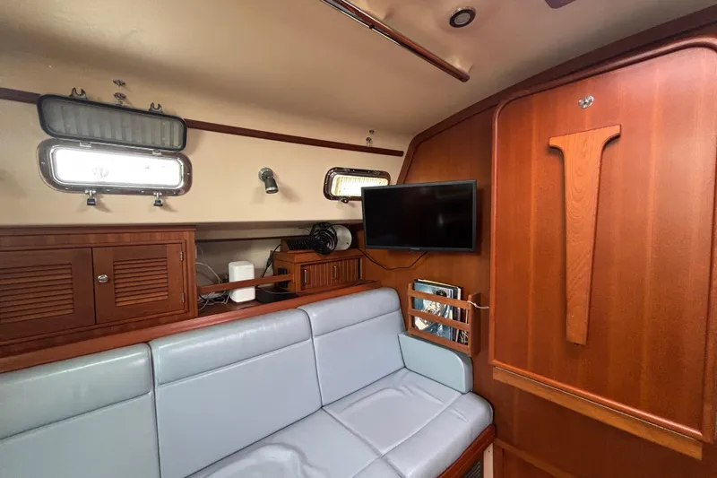 Moondance Yacht Photos Pics Interior of 2007 Island Packet 370 sailboat with wood paneling and seating area.