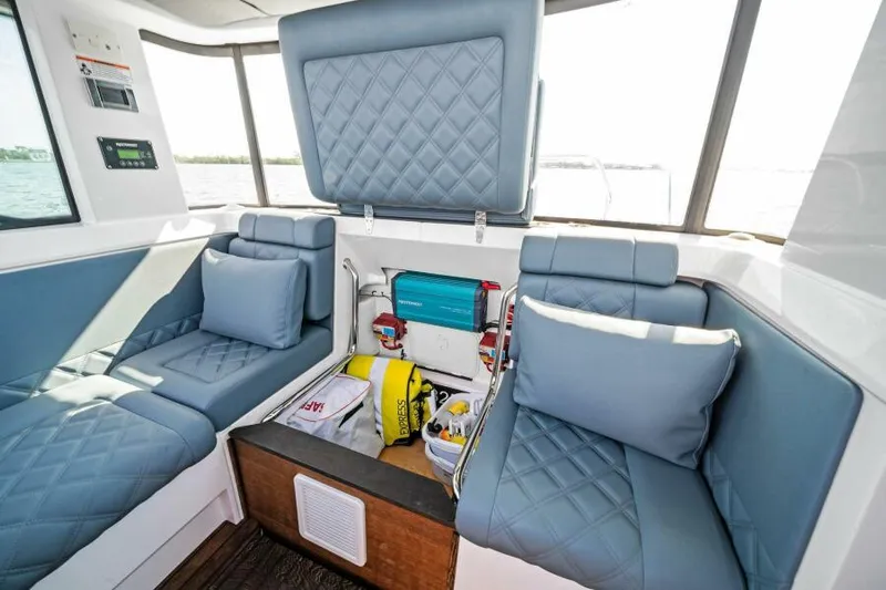  Yacht Photos Pics Interior of 2022 Axopar 37 Cross Cabin with blue seating and storage compartment.