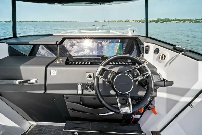  Yacht Photos Pics 2022 Axopar 37 Cross Cabin helm with modern controls, steering wheel, and panoramic water view.