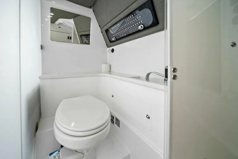  Yacht Photos Pics 2022 Axopar 37 Cross Cabin bathroom with modern fixtures and compact design.