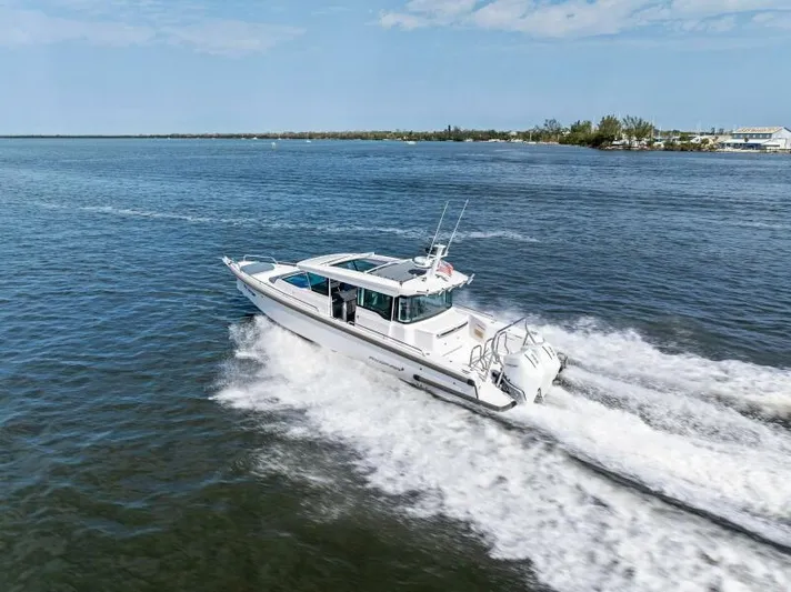  Yacht Photos Pics 2022 Axopar 37 Cross Cabin boat cruising on open water.