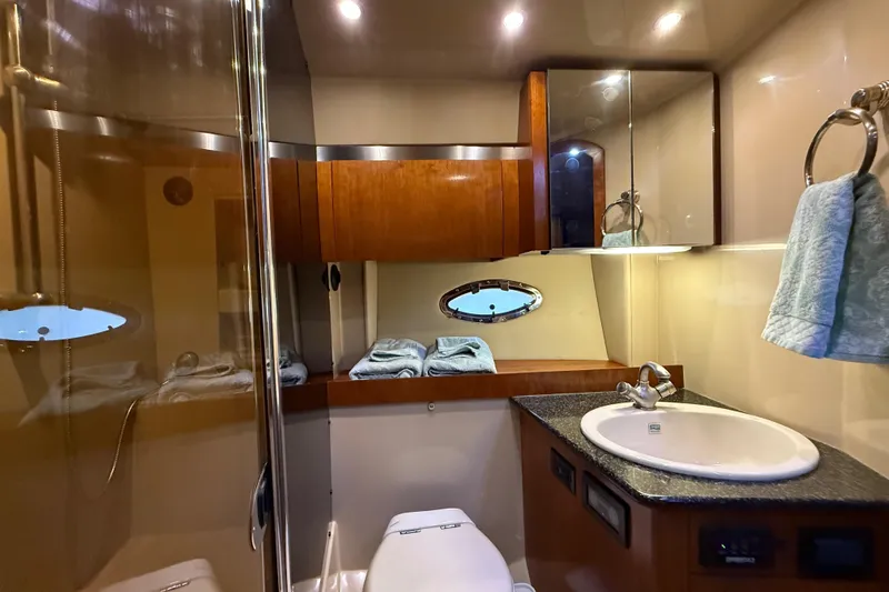  Yacht Photos Pics Luxurious bathroom in 2005 Cruisers Yachts 420 Express with modern fixtures and elegant wood cabinetry.
