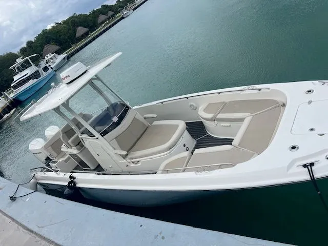  Yacht Photos Pics 2022 Boston Whaler DAUNTLESS boat docked in a marina, featuring sleek design and spacious seating.