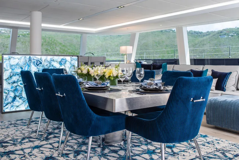 Relentless II Yacht Photos Pics Luxurious dining area on 2022 Sunreef 80 Sail yacht with elegant blue chairs and modern decor.