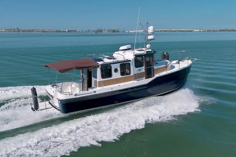  Yacht Photos Pics 2011 Ranger Tugs R-29 cruising on calm waters under clear blue skies.