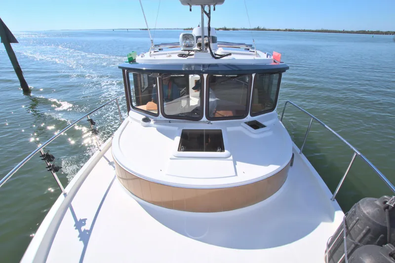  Yacht Photos Pics 2011 Ranger Tugs R-29 boat cruising on calm water under clear blue sky.