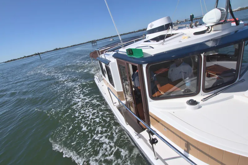  Yacht Photos Pics 2011 Ranger Tugs R-29 cruising on open water under clear blue skies.