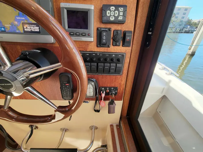  Yacht Photos Pics 2011 Ranger Tugs R-29 helm with steering wheel, navigation controls, and waterfront view.