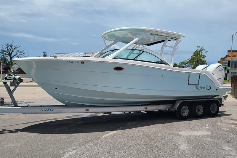  Yacht Photos Pics 2024 Robalo R317 Dual Console boat on a trailer in a parking lot.