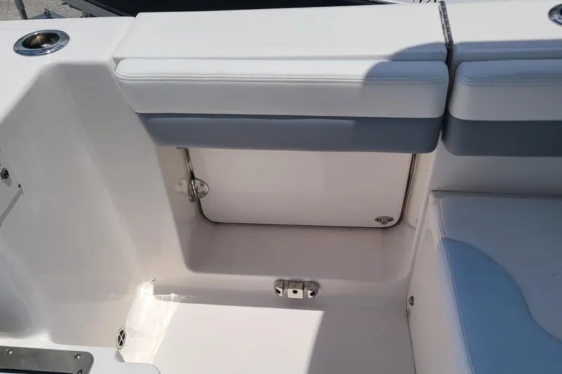  Yacht Photos Pics 2024 Robalo R317 Dual Console boat seating area with storage compartment.