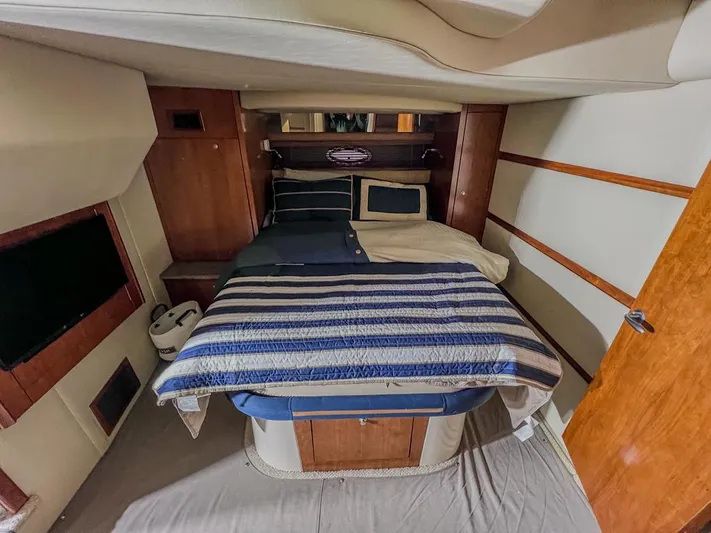  Yacht Photos Pics Interior cabin of 2008 Cruisers Yachts 460 Express with cozy bed and striped bedding.