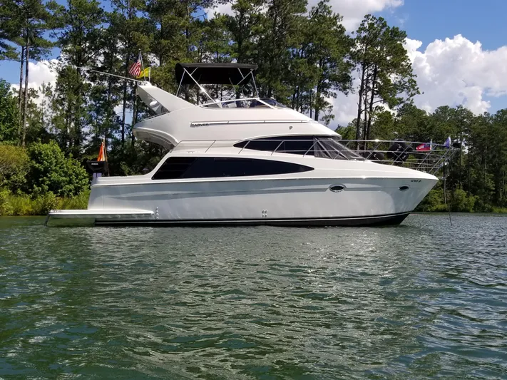  Yacht Photos Pics 2004 Carver 360 Sport Sedan yacht on a serene lake, surrounded by lush trees.